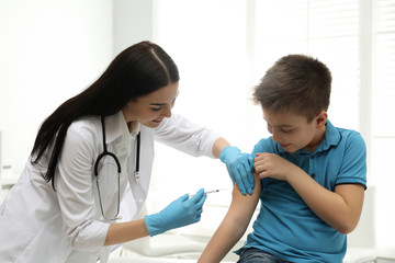 Sticker - Doctor vaccinating little child in modern clinic