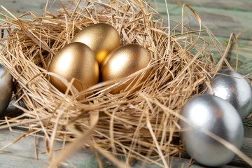 Wall Mural - Eggs in a nest. Easter golden and silver eggs