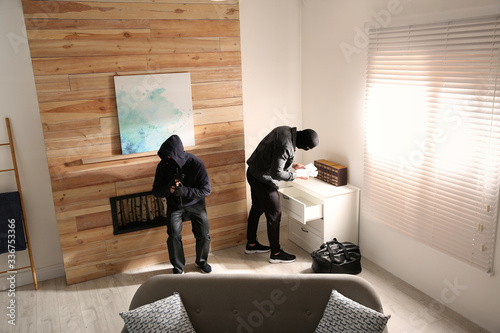 Fotomural Dangerous masked criminals stealing money from house