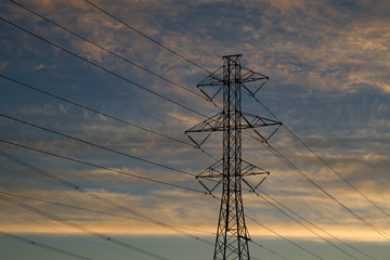 Power lines against sunset sky and clouds