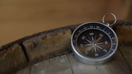 Wall Mural - Vintage compass close up on an old wooden barrel