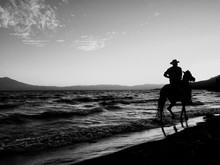 Man Riding Horse On Beach Against Sky