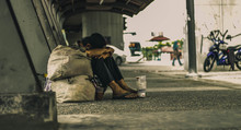 Beggar Sitting Under Bridge