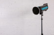 © fotodrobik - Large professional photo studio lamps on a white brick wall.