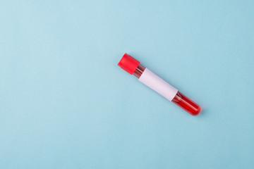 Novel corornavirus test concept. Top above overhead close up view photo of vial with blood sample and label on it isolated over blue color background with copy space
