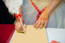 Hands Of Caucasian Wedding People Signing The Document On Wed Ceremony, Close Up View . The Newlyweds Put Their Signature On The Marriage .