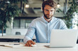 © fotofabrika - Businessman in shirt working on his laptop in an office. Open space office