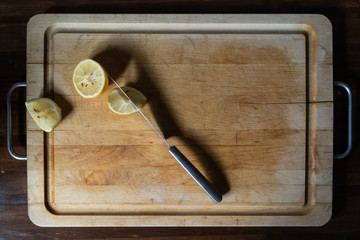 dark lay flat view of cut lemons on old cutting board