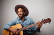 Portrait of happy bearded black man playing guitar isolated on white background.