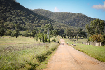 Wall Mural - Two boys riding bikes on rural country road near Mudgee New South Wales