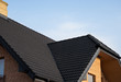 © Volodymyr_sh - Brown metal tile roof. Roof metal sheets. Modern types of roofing materials. Roof of the house, metal roof tile against the blue sky. Building.