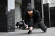 © Volodymyr - Bearded Professional videographer in black hoodie holding professional camera on 3-axis gimbal stabilizer. Filmmaker making a great video with a professional cinema camera. Cinematographer.