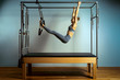© Georgii - Active motivated woman does exercises in bed reformer, beauty and health. Plastic, posture, smart fitness.