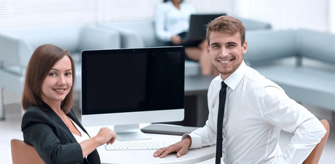 Poster - smiling member of the business team sitting at Desk