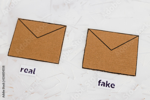 fake emails or online scams, email envelop icons with real vs fake labels on them