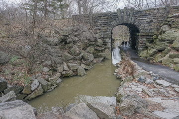 Wall Mural - New York, New York: A stream flows under the Glen Span Arch, in the northwest section of Central Park, on a cloudy day.