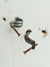 Rusty Nails With Brackets On White Wall