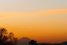 Scenic View Of Silhouette Mountains Against Orange Sky
