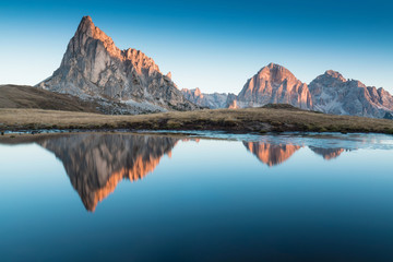 Wall Mural - View of famous Dolomites mountain peaks glowing in beautiful golden morning light at sunrise in summer, South Tyrol,Italy
Ra Gusella and Giau pass reflection in lake.
Famous best alpine place in Alps.