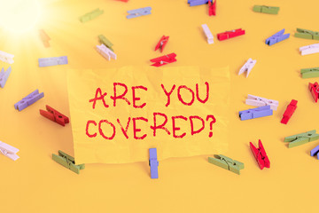 Handwriting text writing Are You Covered Question. Conceptual photo asking showing if they had insurance in work or life Colored clothespin papers empty reminder yellow floor background office