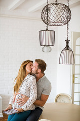 Wall Mural - Happy young couple looking at digital tablet in living room