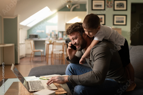 Cheerful father with son working from home Poster Mural XXL