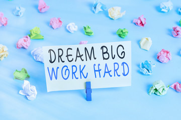 Handwriting text writing Dream Big Work Hard. Conceptual photo Believe in yourself and follow the dreams and goals Colored crumpled papers empty reminder blue floor background clothespin