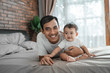 © Odua Images - father bonding with baby. man playing with his daughter on the bed