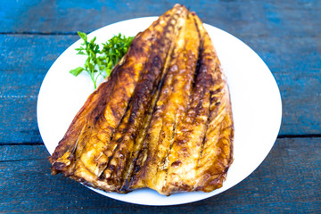 Baked mackerel fish on a white plate