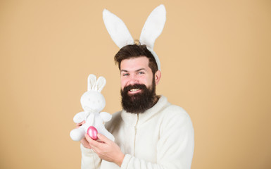 Wall Mural - Man wearing rabbit suit play with toy. Funny bunny man soft ears. Easter activities concept. Still childish. Celebrate Easter. Guy bearded hipster cheerful bunny with long white ears. Easter rabbit