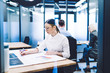 © BullRun - Female office worker drawing blueprint in office