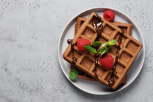 Belgian Chocolate Waffles Decorated With Mint And Raspberries. Gray Background, Top View