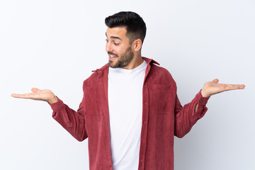 Poster - Young handsome man with beard wearing a corduroy jacket over isolated white background holding copyspace with two hands