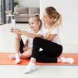 © FreepikCompany - Side view of mother and daughter taking selfie on yoga mat