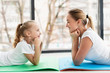 © FreepikCompany - Side view of mother and daughter posing at home on yoga mat