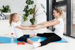 © FreepikCompany - Side view of mother and daughter exercising on yoga mat