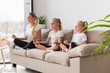 © FreepikCompany - Side view of mother an daughters meditating at home on couch