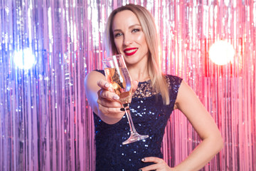 Party, drinks, holidays and celebration concept - smiling woman in evening dress with glass of sparkling wine over shiny background.