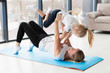 © FreepikCompany - Side view of mother lifting happy daughter in the air while on yoga mat