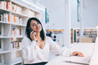 © BullRun - Elegant businesswoman chatting via smartphone in library
