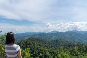 Wall Mural - young cute Japanese Asian hipster girl travelling at beautiful sky 
mountains scenery park hiking garden views at Kanchanaburi Thailand guiding idea for female backpacker woman women backpacking