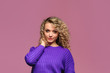 beautiful young woman with curl hair in knitted violet sweater posing on pink background - Image
