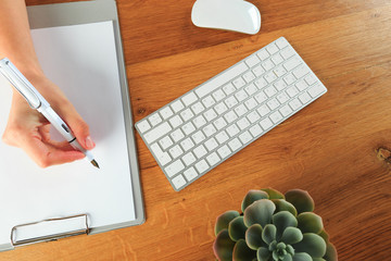 Female hands working on wooden work place with modern gadgets  top view