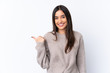 © luismolinero - Young brunette woman over isolated white background pointing to the side to present a product