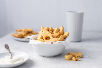 Wall Mural - Cheese crackers, salty snack concept. Cookies, piece of cheese on a gray background