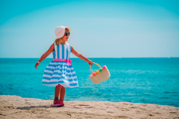 cute little girl with bag on tropical beach
