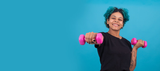 girl or woman doing sport with dumbbells on isolated color background