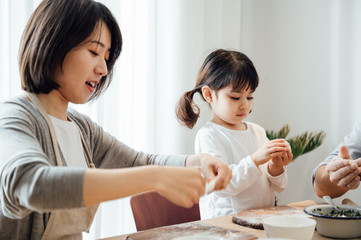 Mom and Dad and daughter at home dumplings