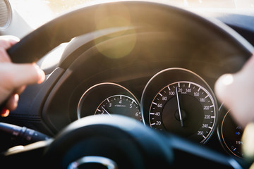 Speedometer of a car close-up, with the arrow frozen at a speed of 120 km/h. Details and interior of a black luxury car.