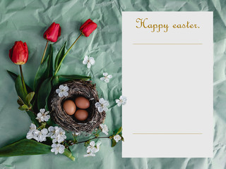 Easter card. Easter eggs in the nest, red tulips and a note with the inscription Happy Easter.